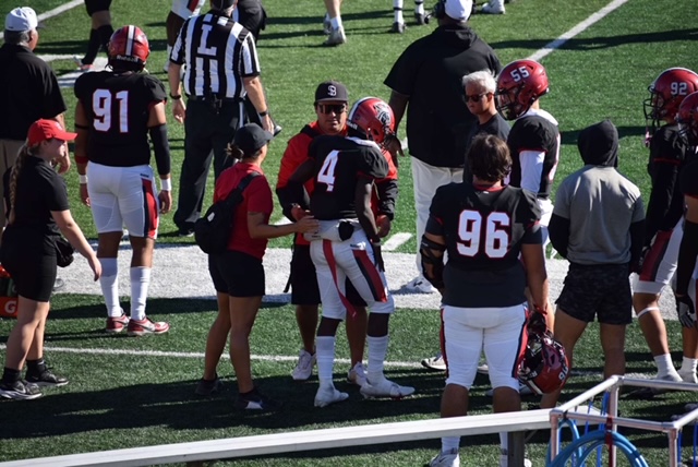 Athletic trainer working with a football player